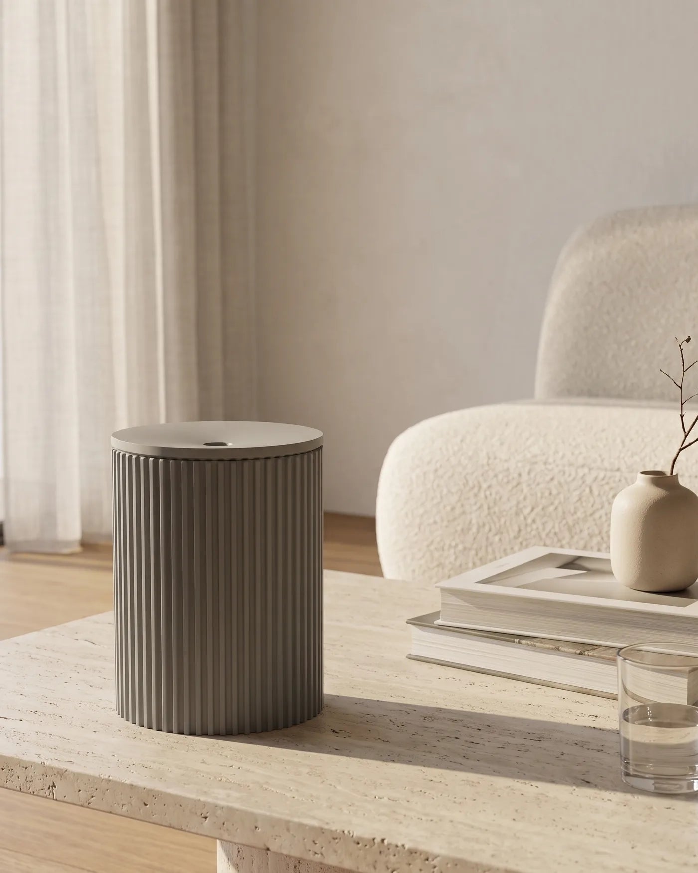 cadou Aschenbecher NEBEL in Hellgrau auf einem Travertin-Couchtisch mit Büchern und Vase